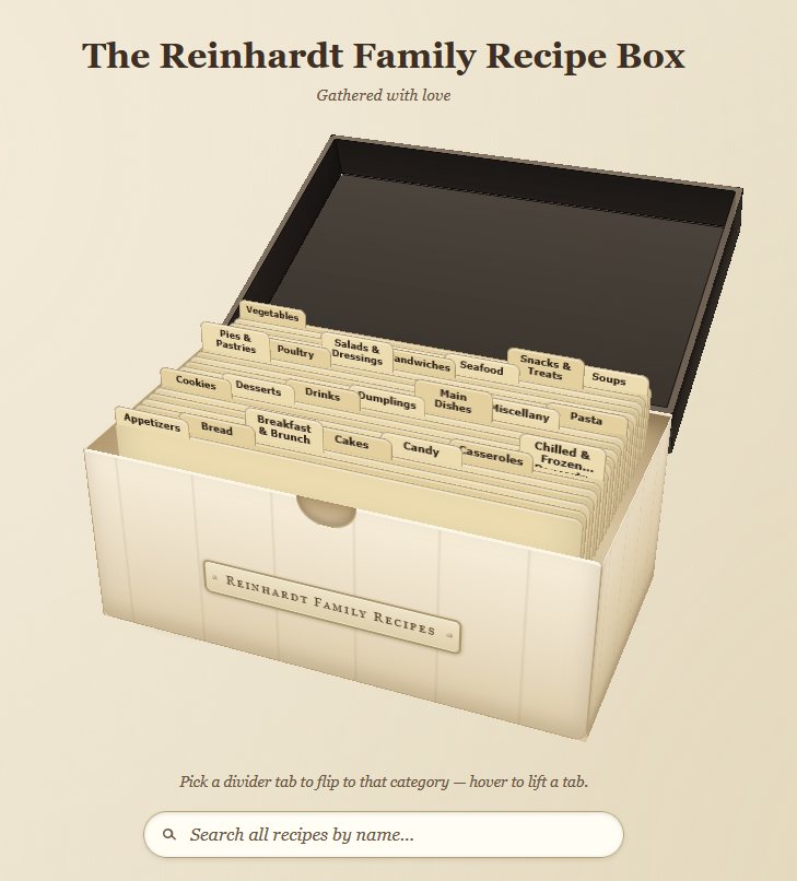 The recipe box rendered in 3D with its lid open, divider tabs labelled by category standing in staggered rows, and an embossed plate reading Reinhardt Family Recipes.